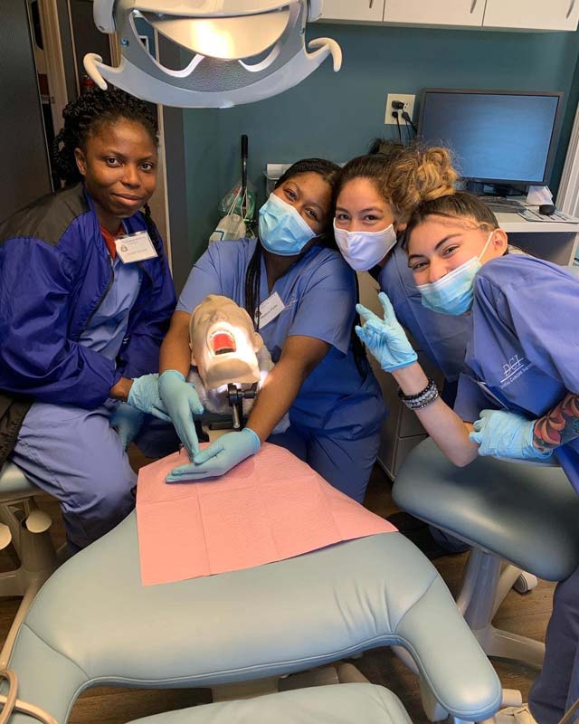 Group of students practicing dental procedures on a training mannequin