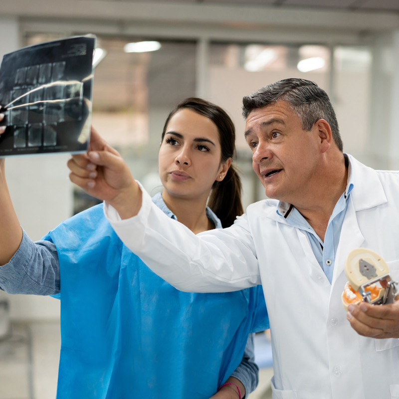 dentist and dental student looking at xrays
